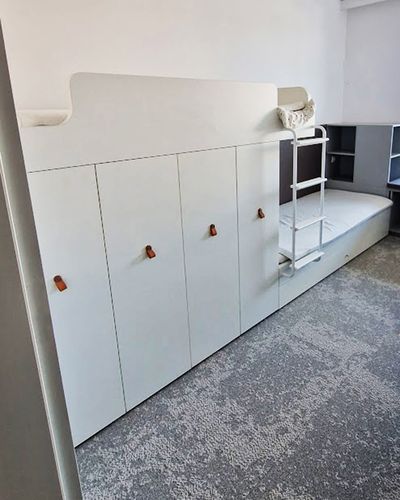 Biela poschodová posteľ so skriňou a rebríkom