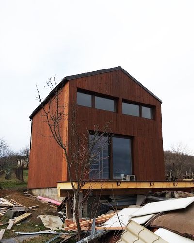 Pergola pripevnená na fasádu domu s bielou konštrukciou