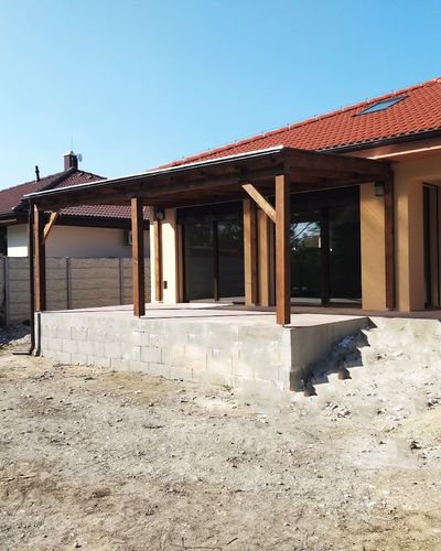 Drevom obložený domček pri vode s terasou