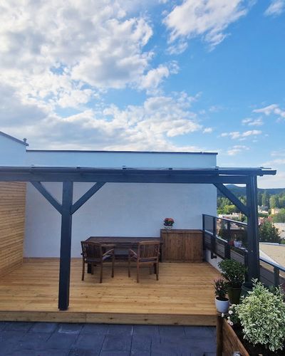 Pergola nad terasou s dlaždicovou podlahou, v podvečer