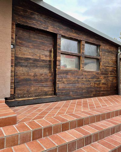 Pergola pripevnená na fasádu domu s bielou konštrukciou, celkový pohľad