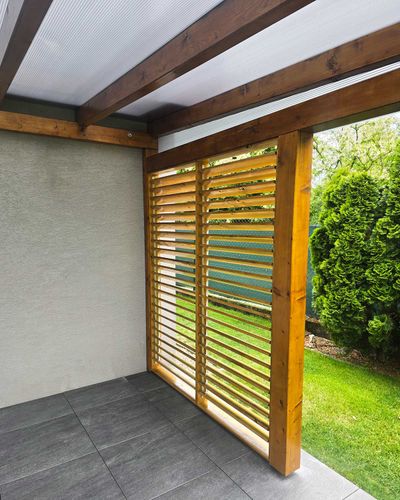 Pergola s dreveným roštom strechy nad terasou, v podvečer