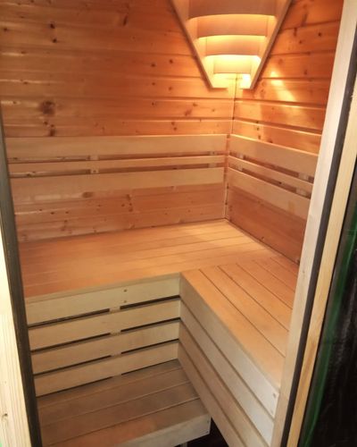 Menšia sauna s drevenými lavicami a stropným svietidlom
